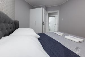 ビャウィストクにあるApartment Royal Iのベッドルーム1室(ベッド1台、タオル2枚付)