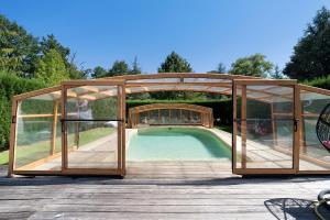 a swimming pool in a pavilion with a bridge at La Table De Pierre - Chambre d'Hôte in Lussas-et-Nontronneau