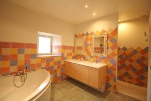 a bathroom with a tub and a sink and a mirror at Fonbanoux in Flavignac +38 photos