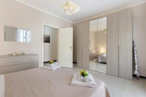 a white bedroom with a bed and a mirror at Appartamento Rina Centro Sicilia in Pietraperzia