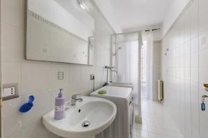 a white bathroom with a sink and a mirror at Appartamento Rina Centro Sicilia in Pietraperzia