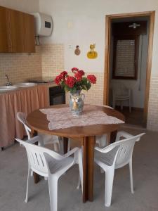 una mesa de cocina con un jarrón de flores. en Il Muretto, en Marettimo