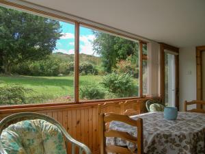 a dining room with a table and a large window at Lower Brae in Achnahanat