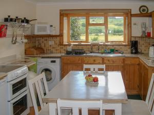 a kitchen with a table with a bowl of fruit on it at Lower Brae in Achnahanat