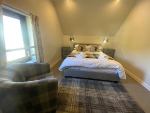 a bedroom with a bed and a chair at Puffin - Bach in Lerags
