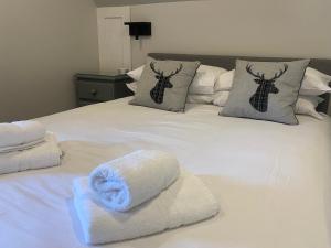 a white bed with towels on top of it at Puffin - Bach in Lerags