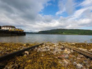 a pair of train tracks next to a body of water at Puffin - Bach in Lerags +2 photos