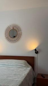 a bedroom with a bed and a mirror on the wall at Casa da Margarida in Castro Marim
