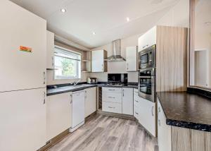 a kitchen with white cabinets and a counter top at Thorness Bay in Porchfield