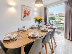 a dining room with a wooden table and chairs at Lodge 52 Una in Carbis Bay