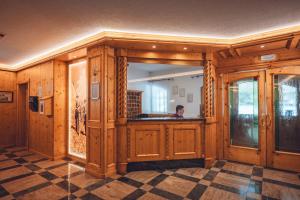a room with wooden walls and a person in a mirror at Aparthotel Princess in Canazei +57 photos