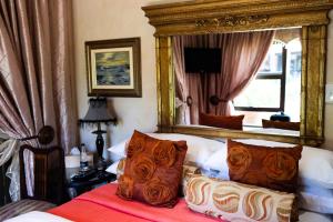 a bedroom with a bed with a large mirror at Tuscan Rose in Bloemfontein