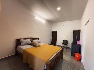 a bedroom with a bed with a yellow blanket at EcoHills in Anachal