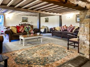 a living room with couches and a table at Broadmeadows Farm in Butterton