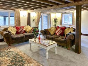 a living room with a couch and a coffee table at Broadmeadows Farm in Butterton