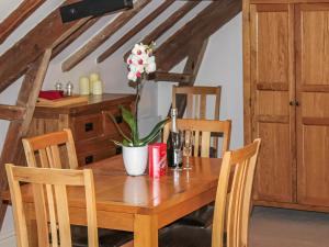a wooden table with a vase of flowers on it at The Granary in Aldbrough