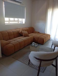 a living room with a brown couch and a chair at טוסקנה הקטנה in Rosh Ha‘Ayin