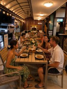 a group of people sitting at a long table at SET INN restaurant & bar 1 & 2 in Kata Beach