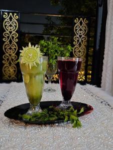 a table with two wine glasses on a table at Thebes Guest house in Jazīrat al ‘Awwāmīyah