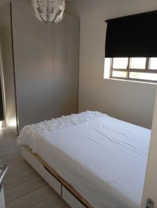 a white bed in a bedroom with a window at טוסקנה הקטנה in Rosh Ha‘Ayin