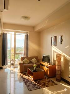 a living room with a couch and a television at Mactan Newtown Deluxe 8 Boulevard Ocean View in Lapu Lapu City