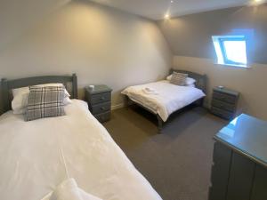 a bedroom with two beds and two night stands at Puffin - Dubh Segir in Lerags