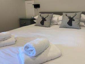 a white bed with towels and pillows on it at Puffin - Dubh Segir in Lerags