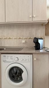 a kitchen with a washing machine and a counter at Casa da Margarida in Castro Marim +12 photos