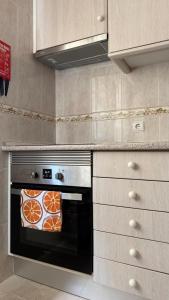 a kitchen with an oven with a pizza in it at Casa da Margarida in Castro Marim