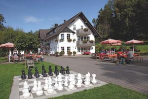 ein großes Schachbrett vor einem Gebäude in der Unterkunft Landgasthof Cafe Gut Ahe in Kirchhundem