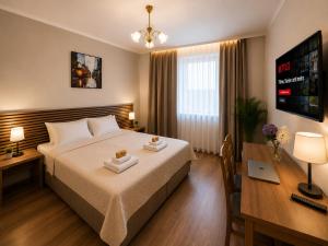 ein Hotelzimmer mit Bett und Schreibtisch in der Unterkunft Hotel M in Nürnberg