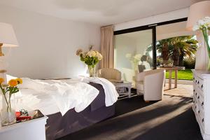 a hotel room with a large bed and a large window at Mangio Fango Hotel et Spa in Saintes-Maries-de-la-Mer