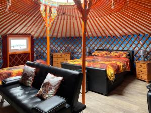 a bedroom with a bed and a couch in a yurt at Orange Yurt - Uk48018 in Gamrie