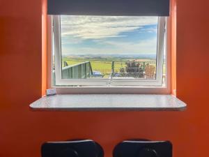 a window in a room with two chairs looking out at Orange Yurt - Uk48018 in Gamrie