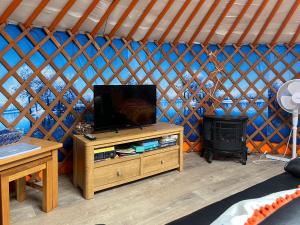 a room with a tv and a stove in a yurt at Orange Yurt - Uk48018 in Gamrie