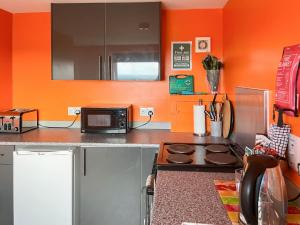a kitchen with a stove and a microwave at Orange Yurt - Uk48018 in Gamrie +13 photos