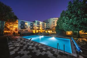 a large building with a swimming pool at night at Hotel Jana in Přerov