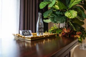 a bottle sitting on a table next to a plant at Tuscan Rose in Bloemfontein
