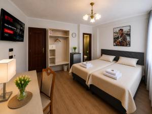 ein Schlafzimmer mit einem Bett, einem Schreibtisch und einem Tisch in der Unterkunft Hotel M in Nürnberg