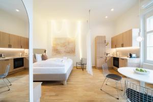 a bedroom with a bed and a table and chairs at GH Luxury Apartments Graz, Gösser Haus in Graz