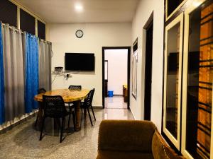 a dining room with a table and chairs and a tv at EcoHills in Anachal