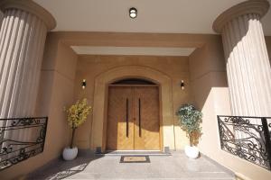 a front door of a building with two vases at weston west in 6th Of October