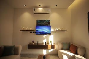 a living room with a couch and a tv on the wall at weston west in 6th Of October
