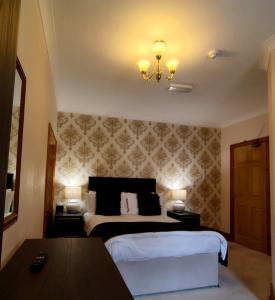 a hotel room with a bed and a chandelier at Pinewood House in Whitby +3 photos