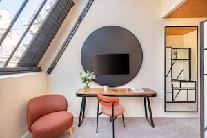 a room with a desk and two chairs and a tv at Maison Honnel in Paris