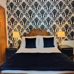 a bedroom with a large bed with blue pillows at Pinewood House in Whitby