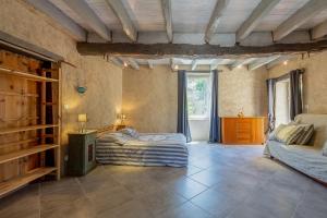 a large room with two beds and a window at Maison de Charme en Pleine Nature in Bournazel