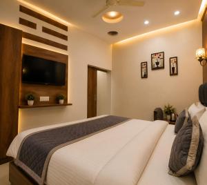 a bedroom with a large bed and a flat screen tv at Hotel KMG Air Cooled,Zirakhpur Chandigarh ,Couple first choice ,verified hotel in Zirakpur