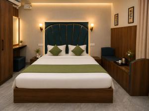 a bedroom with a large bed with a green headboard at Hotel KMG Air Cooled,Zirakhpur Chandigarh ,Couple first choice ,verified hotel in Zirakpur +15 photos