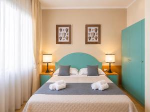 a bedroom with a large bed with two towels at Hotel Stella D'Italia in Viareggio +29 photos